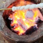 Stockbrot über einer traditionellen thailändischen Feuerstelle